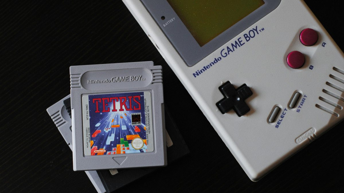 Une console de jeu portable datant de plusieurs ann&eacute;es avec deux jeux.