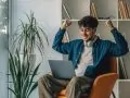 Young Man At Home With Laptop On The Sofa Excited With Joy And Success